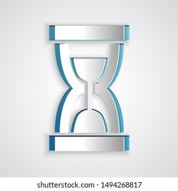 Paper cut Old hourglass with flowing sand icon isolated on grey background. Sand clock sign. Business and time management concept. Paper art style. Vector Illustration