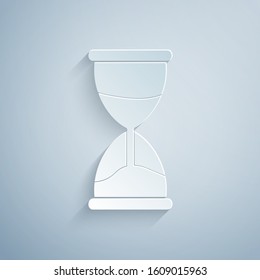 Paper cut Old hourglass with flowing sand icon isolated on grey background. Sand clock sign. Business and time management concept. Paper art style. Vector Illustration