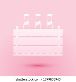 Paper cut Pack of beer bottles icon isolated on pink background. Wooden box and beer bottles. Case crate beer box sign. Paper art style. Vector.