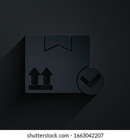 Paper cut Package box with check mark icon isolated on black background. Parcel box. Approved delivery or successful package receipt. Paper art style. Vector Illustration