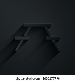 Paper cut Picnic table with benches on either side of the table icon isolated on black background. Paper art style. Vector Illustration
