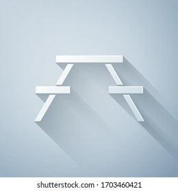 Tabla Picnic con bancos a ambos lados del icono de la mesa aislada en fondo gris. Estilo de arte de papel. Ilustración vectorial