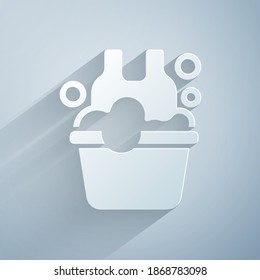 Paper cut Plastic basin with soap suds icon isolated on grey background. Bowl with water. Washing clothes, cleaning equipment. Paper art style. Vector