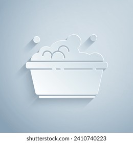 Paper cut Plastic basin with soap suds icon isolated on grey background. Bowl with water. Washing clothes, cleaning equipment. Paper art style. Vector Illustration