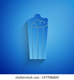 Paper cut Popcorn in cardboard box icon isolated on blue background. Popcorn bucket box. Paper art style. Vector Illustration