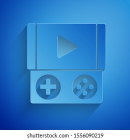 Paper cut Portable video game console icon isolated on blue background. Gamepad sign. Gaming concept. Paper art style. Vector Illustration