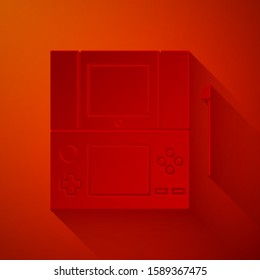 Paper cut Portable video game console icon isolated on red background. Gamepad sign. Gaming concept. Paper art style. Vector Illustration