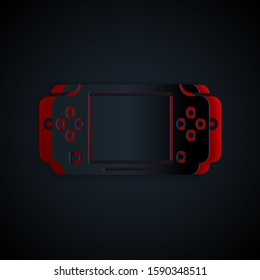 Paper cut Portable video game console icon isolated on black background. Gamepad sign. Gaming concept. Paper art style. Vector Illustration