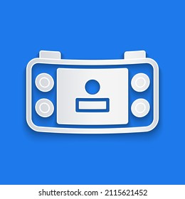 Paper cut Portable video game console icon isolated on blue background. Handheld console gaming. Paper art style. Vector