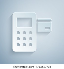 Paper cut Pos terminal with inserted credit card icon isolated on grey background. Payment terminal transaction. Paper art style. Vector Illustration