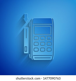 Paper cut Pos terminal with inserted credit card icon isolated on blue background. Payment terminal transaction. Pay by card. Paper art style. Vector Illustration