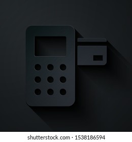 Paper cut Pos terminal with inserted credit card icon isolated on black background. Payment terminal transaction. Paper art style. Vector Illustration