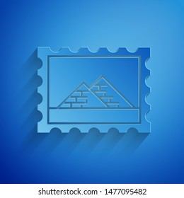 Paper cut Postal stamp and Egypt pyramids icon isolated on blue background. Paper art style. Vector Illustration