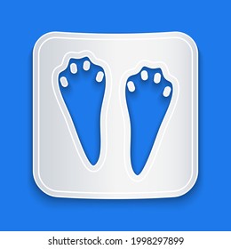Paper cut Rabbit and hare paw footprint icon isolated on blue background. Paper art style. Vector
