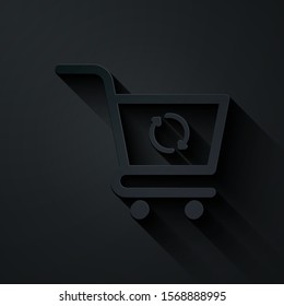 Paper cut Refresh shopping cart icon isolated on black background. Online buying concept. Delivery service sign. Update supermarket basket symbol. Paper art style. Vector Illustration