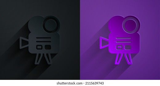 Paper cut Retro cinema camera icon isolated on black on purple background. Video camera. Movie sign. Film projector. Paper art style. Vector
