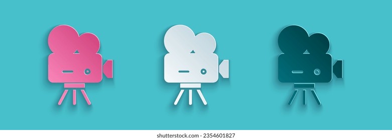 Paper cut Retro cinema camera icon isolated on blue background. Video camera. Movie sign. Film projector. Paper art style. Vector Illustration