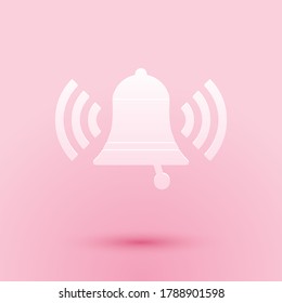 Paper cut Ringing bell icon isolated on pink background. Alarm symbol, service bell, handbell sign, notification symbol. Paper art style. Vector.
