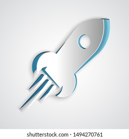 Paper cut Rocket ship with fire icon isolated on grey background. Space travel. Paper art style. Vector Illustration