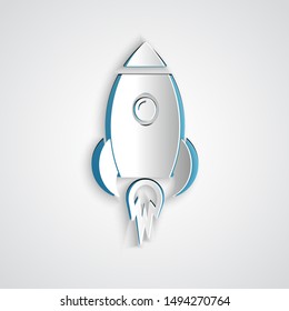 Paper cut Rocket ship with fire icon isolated on grey background. Space travel. Paper art style. Vector Illustration