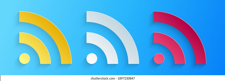 Paper cut RSS icon isolated on blue background. Radio signal. RSS feed symbol. Paper art style. Vector.