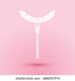 Paper cut Sausage on the fork with steam icon isolated on pink background. Grilled sausage and aroma sign. Paper art style. Vector.