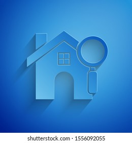 Paper cut Search house icon isolated on blue background. Real estate symbol of a house under magnifying glass. Paper art style. Vector Illustration
