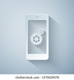 Paper cut Setting on smartphone screen icon isolated on grey background. Mobile phone and gear sign. Adjusting app, set options, repair, fixing phone concepts. Paper art style. Vector Illustration