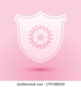 Paper cut Shield with gear icon isolated on pink background. Paper art style. Vector.