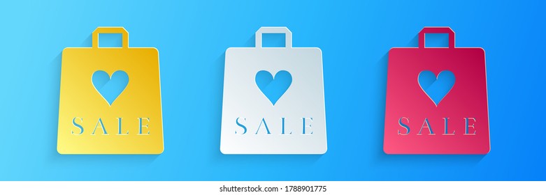 Paper cut Shoping bag with an inscription Sale icon isolated on blue background. Handbag sign. Woman bag icon. Female handbag sign. Paper art style. Vector.