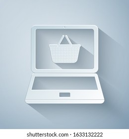 Paper cut Shopping basket on screen laptop icon isolated on grey background. Concept e-commerce, e-business, online business marketing. Paper art style. Vector Illustration