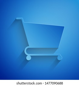 Paper cut Shopping cart icon isolated on blue background. Online buying concept. Delivery service sign. Supermarket basket symbol. Paper art style. Vector Illustration