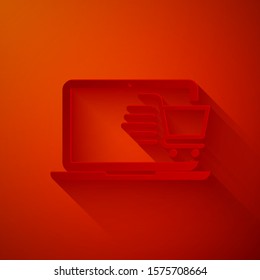 Paper cut Shopping cart on screen laptop icon isolated on red background. Concept e-commerce, e-business, online business marketing. Paper art style. Vector Illustration