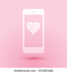 Paper cut Smartphone with heart rate monitor function icon isolated on pink background. Paper art style. Vector.