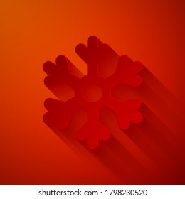 Icono de copo de nieve cortado con papel aislado en fondo rojo. Estilo de arte de papel. Ilustración vectorial