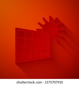 Paper cut Solar energy panel and sun icon isolated on red background. Paper art style. Vector Illustration