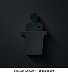 Paper cut Speaker icon isolated on black background. Orator speaking from tribune. Public speech. Person on podium. Paper art style. Vector Illustration