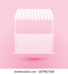 Paper cut Street stall with awning and wooden rack icon isolated on pink background. Kiosk with wooden rack. Paper art style. Vector.