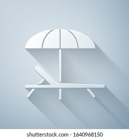Paper cut Sunbed icon isolated on grey background. Beach umbrella and Sun lounger. Paper art style. Vector Illustration