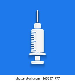 Paper cut Syringe icon isolated on blue background. Syringe for vaccine, vaccination, injection, flu shot. Medical equipment. Paper art style. Vector Illustration