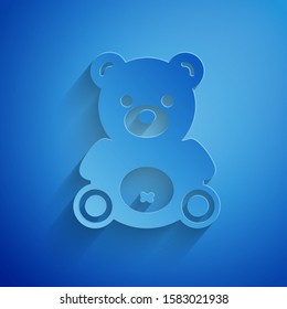 Paper cut Teddy bear plush toy icon isolated on blue background. Paper art style. Vector Illustration