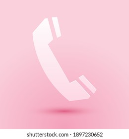 Paper cut Telephone handset icon isolated on pink background. Phone sign. Call support center symbol. Communication technology. Paper art style. Vector.