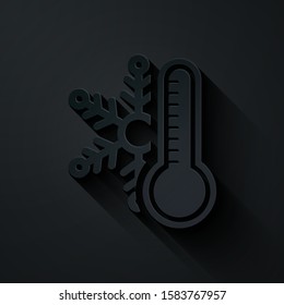 Paper cut Thermometer with snowflake icon isolated on black background. Paper art style. Vector Illustration