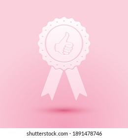 Paper cut Thumbs up on medal badge with ribbons icon isolated on pink background. Paper art style. Vector.