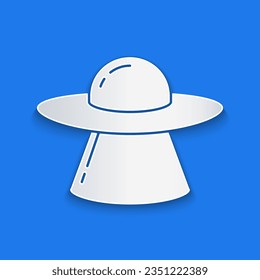 Paper cut UFO flying spaceship icon isolated on blue background. Flying saucer. Alien space ship. Futuristic unknown flying object. Paper art style. Vector