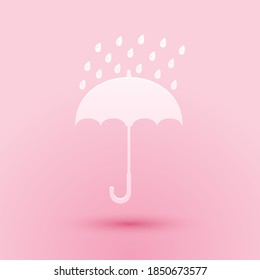 Paper cut Umbrella and rain drops icon isolated on pink background. Paper art style. Vector.