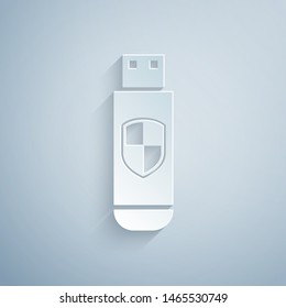 Paper cut USB flash drive and protection shield icon isolated on grey background. Paper art style. Vector Illustration