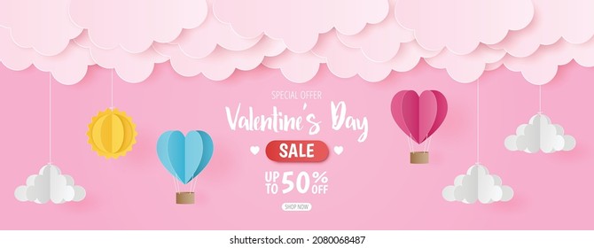 Paper cut of Valentine's Day sale background with pink and blue heart hot air balloons, sun and cloud on pink background, banner template