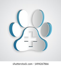 Paper cut Veterinary clinic symbol icon isolated on grey background. Cross hospital sign. A stylized paw print dog or cat. Pet First Aid sign. Paper art style. Vector Illustration