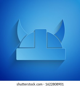 Paper cut Viking in horned helmet icon isolated on blue background. Paper art style. Vector Illustration